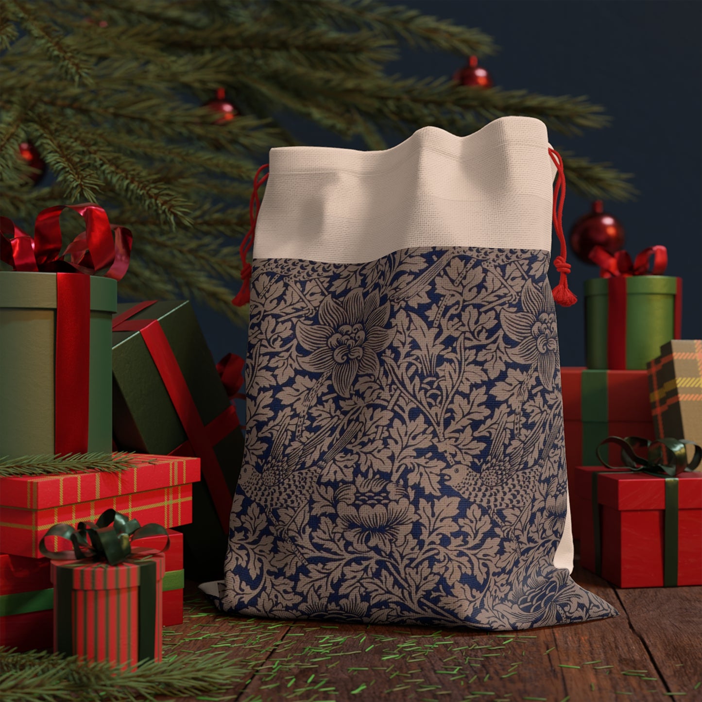 A beige linen drawstring bag with a floral pattern inspired by William Morris, featuring a red drawstring at the top.