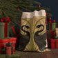 Decorative artwork on a santa sack of two black swans with green reeds and yellow flowers on a beige background.
