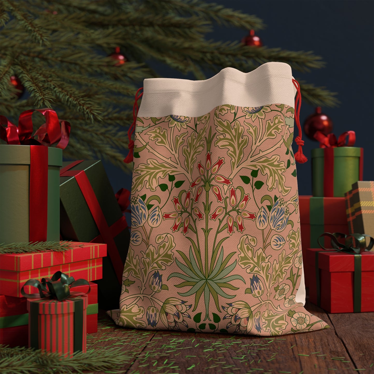 A rectangular Christmas Santa Sack with a floral pattern inspired by William Morris, in colours pink, green, and red, with a white top and red drawstrings.