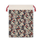 A rectangular Christmas-themed linen drawstring bag with a floral pattern, primarily in red and green colours, and a red drawstring at the top.