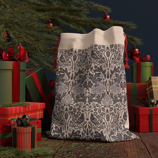 Decorative fabric bag with a floral pattern in front of Christmas presents and tree.