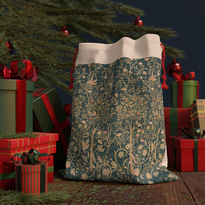 A Christmas Santa sack with a floral William Morris & Co pattern in green, beige, and gold colours, featuring a white drawstring and red ties.