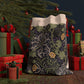 A Christmas Santa Sack with a yellow flower and seaweed pattern, inspired by William Morris, with red drawstrings.