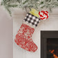 Red and white Christmas stocking hanging on a fireplace with decorative elements.