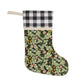 A one-sided printed Christmas stocking with a floral design, featuring a red and black plaid top cuff and a green body.