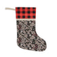 A Christmas stocking with a floral pattern in a red and black or white and black checkered design, featuring a wooden hanging loop.