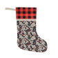 A Christmas stocking with a floral pattern in red, black, and white colours, featuring a plaid design on the top cuff.