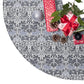 Decorative Christmas tree skirt with a gray and white pattern, surrounded by Christmas decorations.