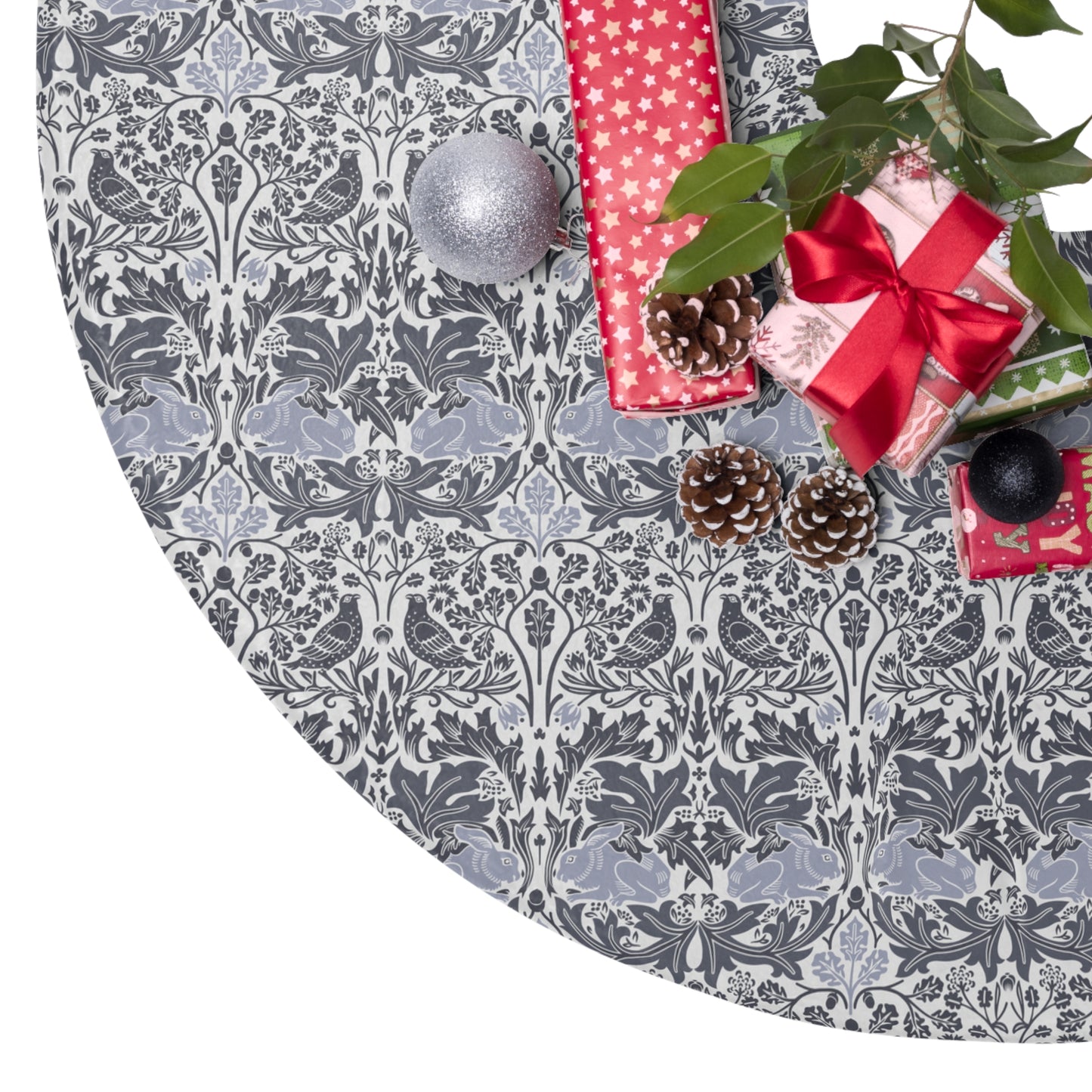 Decorative Christmas tree skirt with a gray and white pattern, surrounded by Christmas decorations.