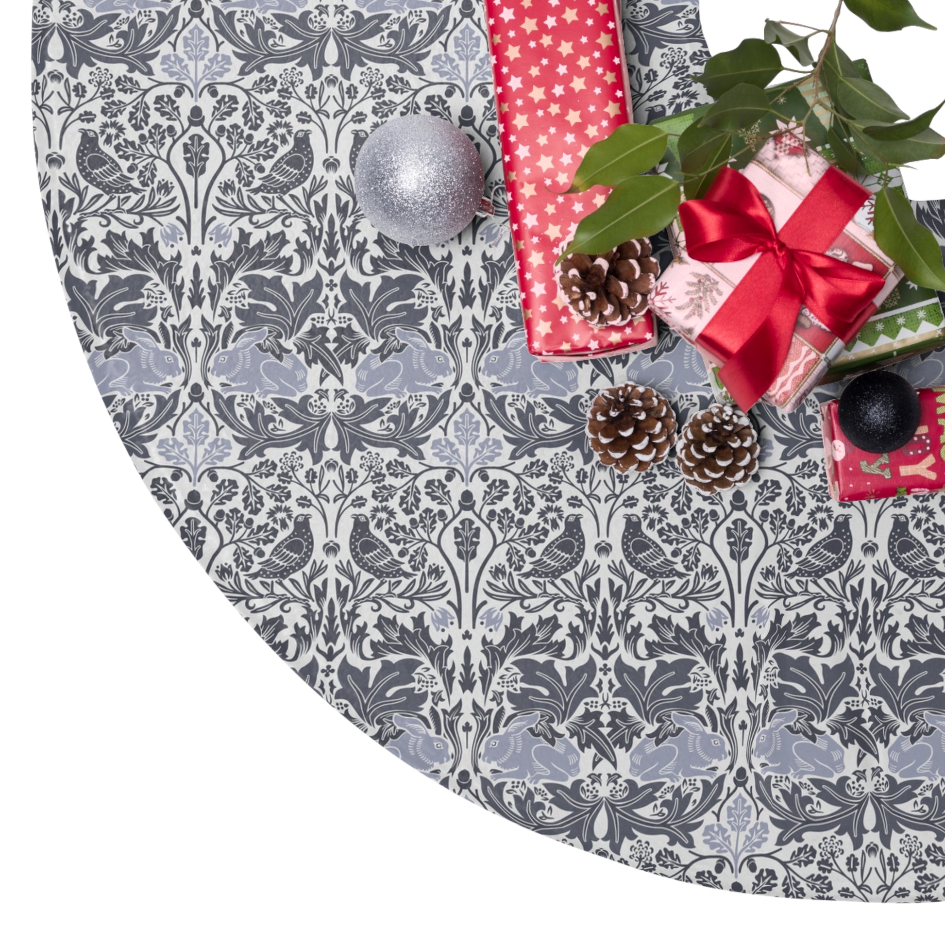 Decorative Christmas tree skirt with a gray and white pattern, surrounded by Christmas decorations.