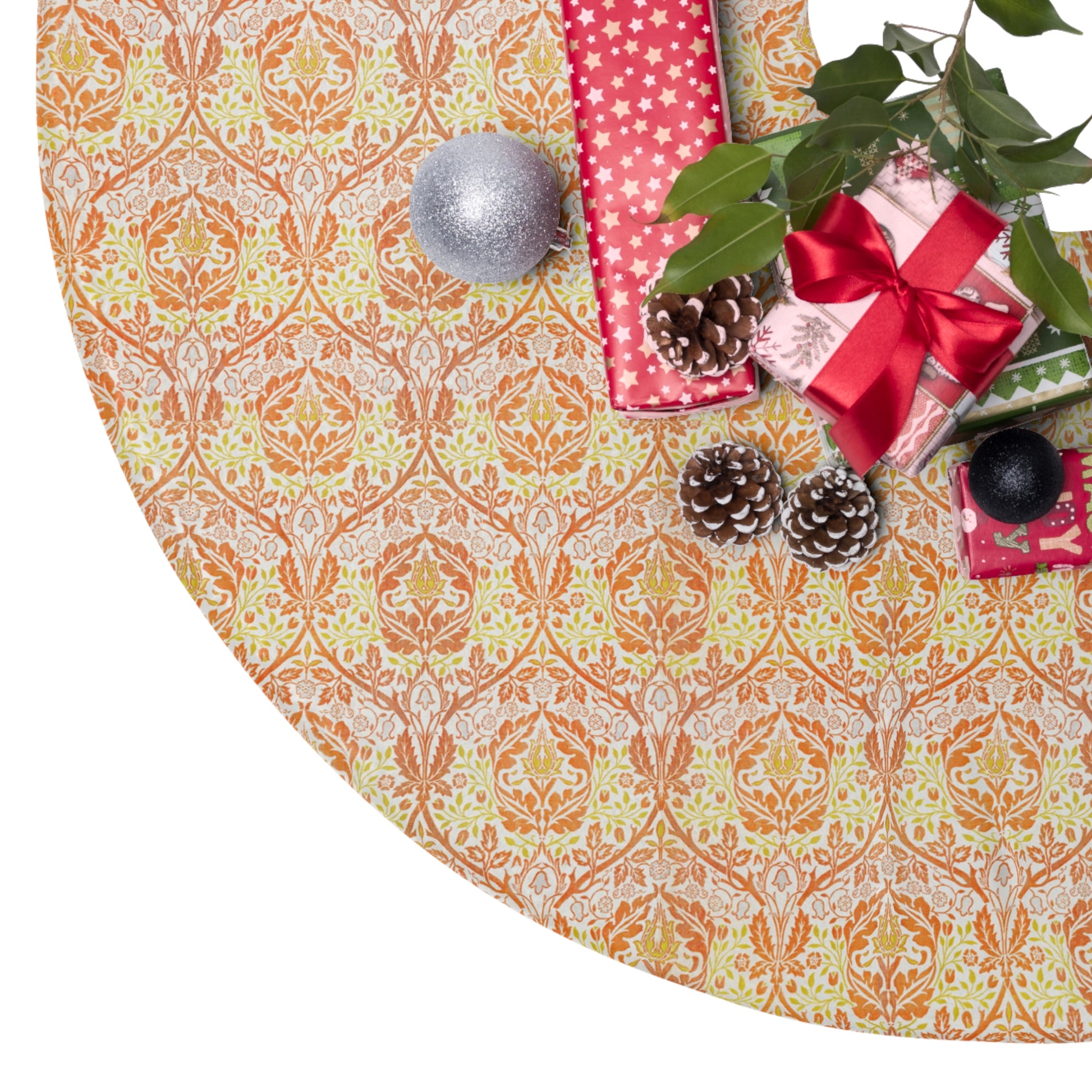 Decorative Christmas tree skirt with pattern, surrounded by gift boxes and ornaments on a white background.
