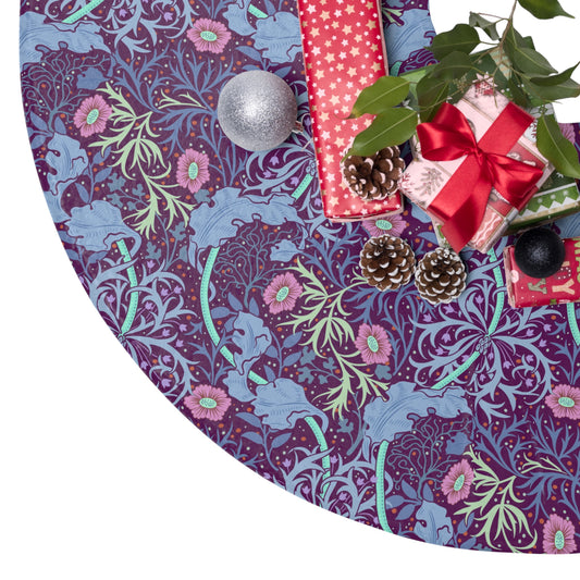 A Christmas tree skirt with a pink floral pattern based on the William Morris Seaweed Collection, displayed around the base of a Christmas tree.
