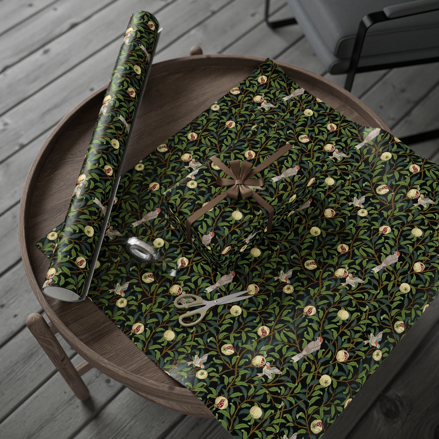 Roll of green floral wrapping paper on a wooden tray with scissors.