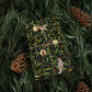Gift wrapped in a decorative paper with birds and leaves, surrounded by pine branches and cones.