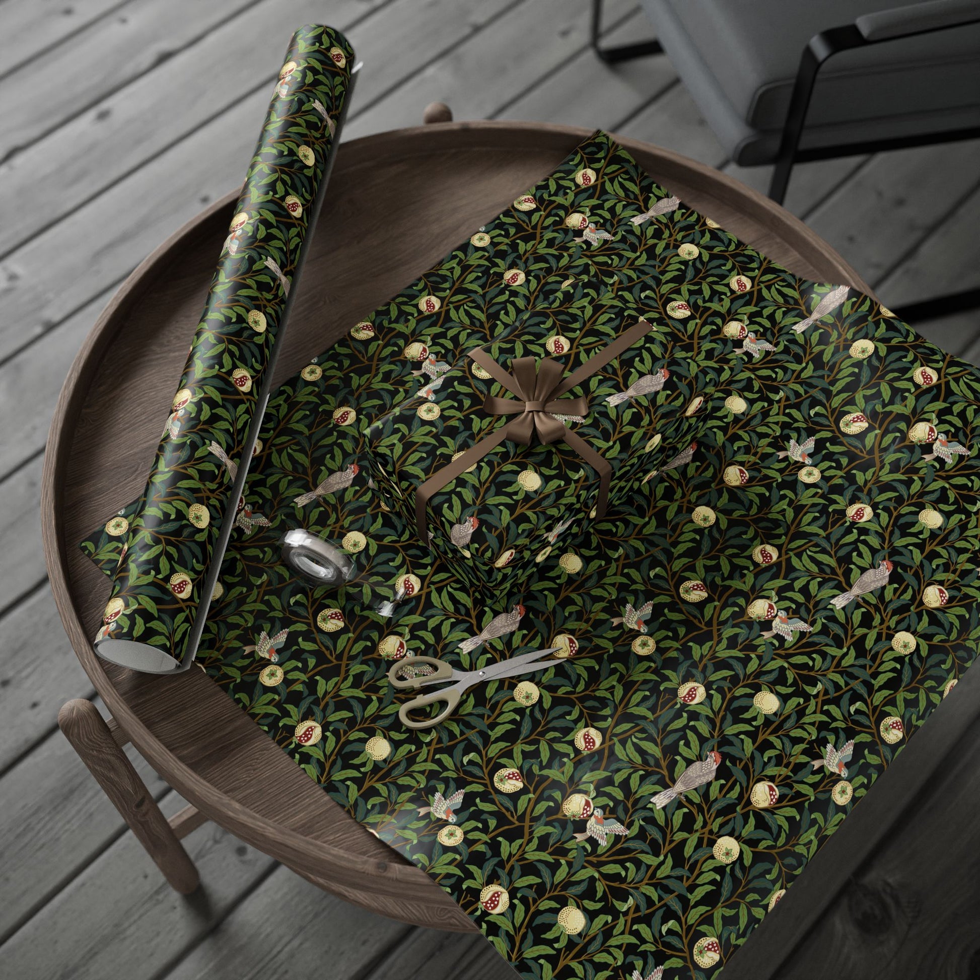 Roll of green floral wrapping paper on a wooden tray with scissors.