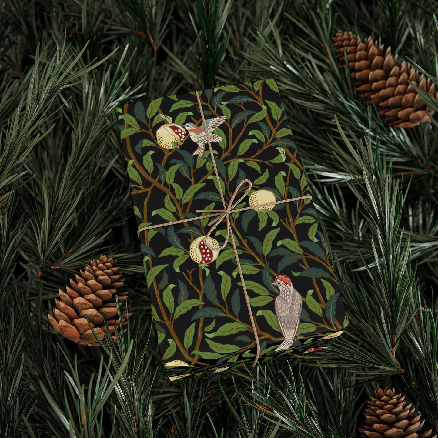 Gift wrapped in a decorative paper with birds and leaves, surrounded by pine branches and cones.