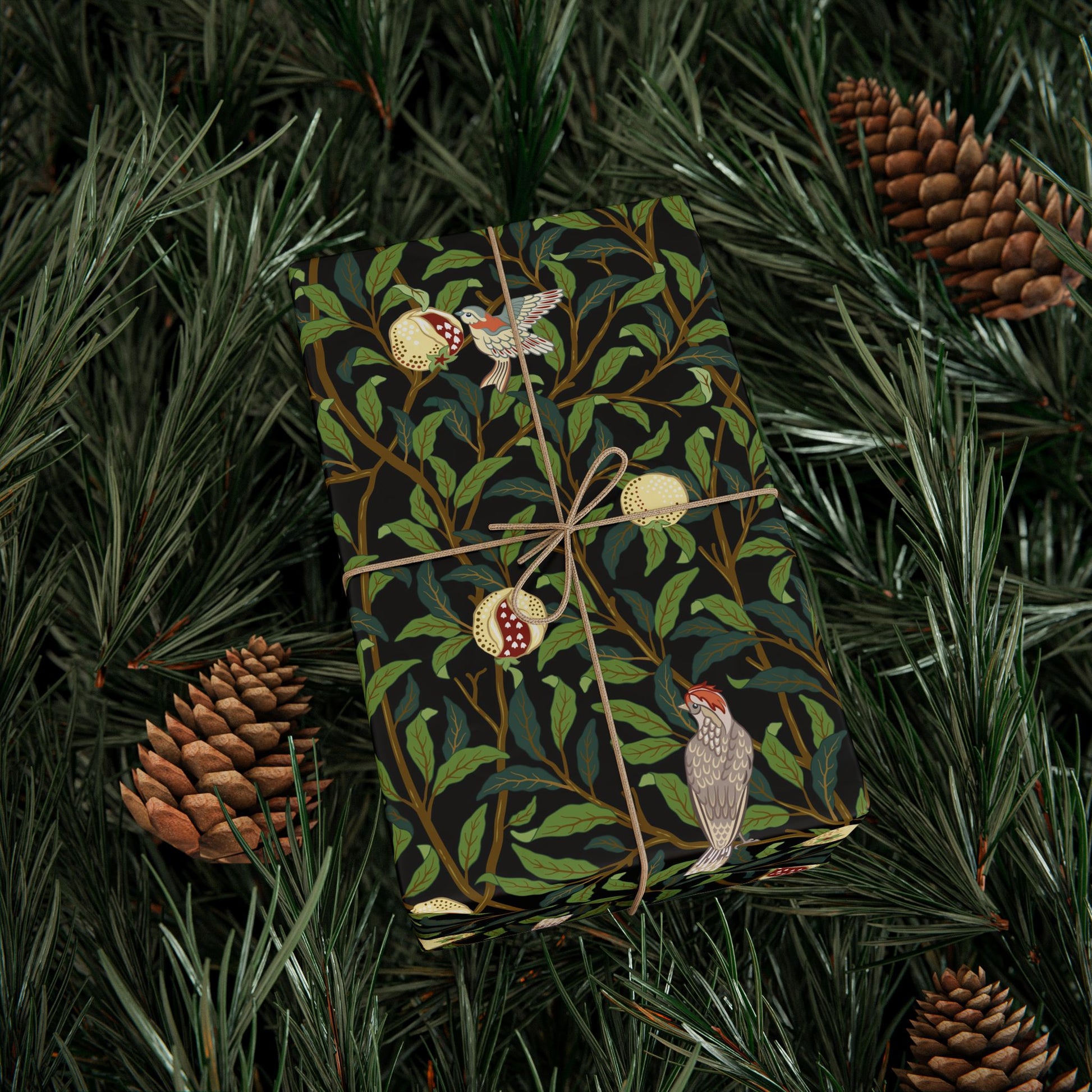 Gift wrapped in a decorative paper with birds and leaves, surrounded by pine branches and cones.
