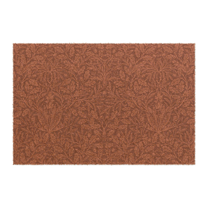A rectangular coconut coir doormat with an intricate floral William Morris & Co pattern in a rust colour, mainly for outdoor use.
