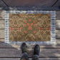 A rectangular decorative doormat with a floral pattern and plaid border, shown on a wooden deck with a person's feet in black sneakers standing at the bottom edge.