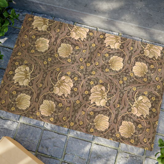 A rectangular coconut coir doormat with an intricate floral William Morris & Co pattern in shades of lavender and gold, with a black vinyl backing.