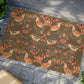 Decorative doormat with floral and bird pattern on a stone floor.