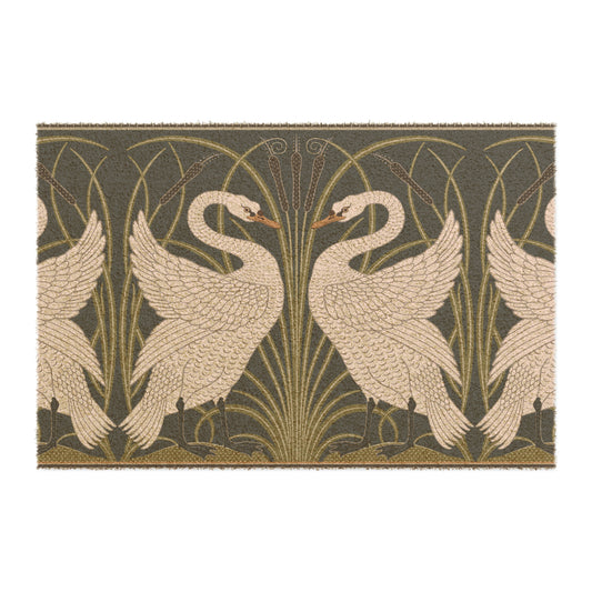 A rectangular doormat featuring a design of two white swans with a green and gold floral background, on a spruce green background.