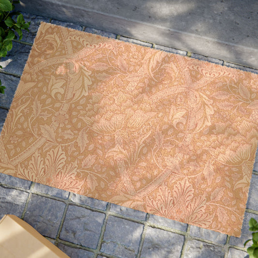 A rectangular area rug with an ornate floral and botanical damask pattern in warm peach, tan, and muted pink tones, shown laid out on a gray stone paver surface outdoors.