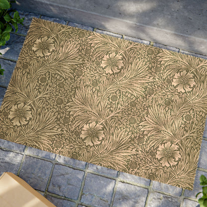 A rectangular area rug with a classic floral and leaf pattern in warm beige and olive green, laid out on a gray stone paver surface.