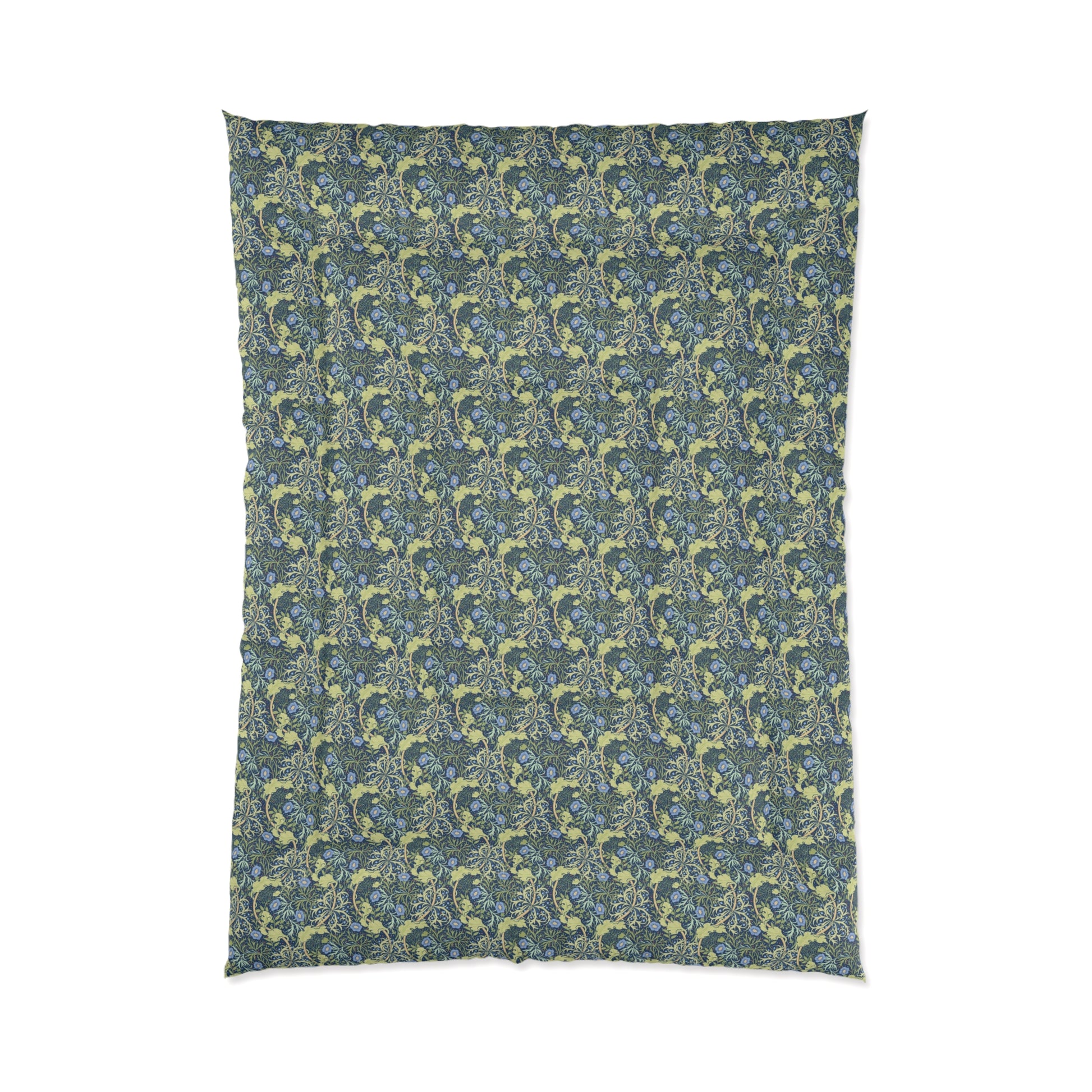 A folded comforter with a blue floral pattern inspired by William Morris's Seaweed Collection.