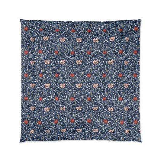 A square-shaped comforter with a blue background featuring a repeating William Morris & Co pattern of red and white apple designs and a plush batting layer visible on one side.