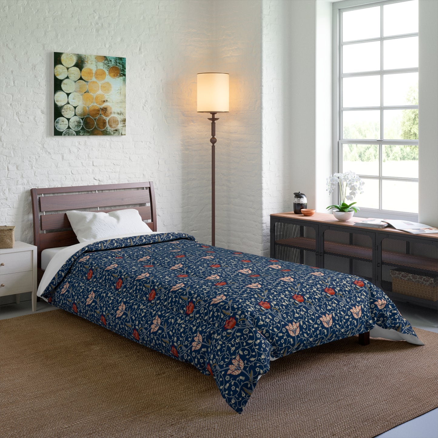 A square-shaped comforter with a blue background featuring a repeating William Morris & Co pattern of red and white apple designs and a plush batting layer visible on one side.