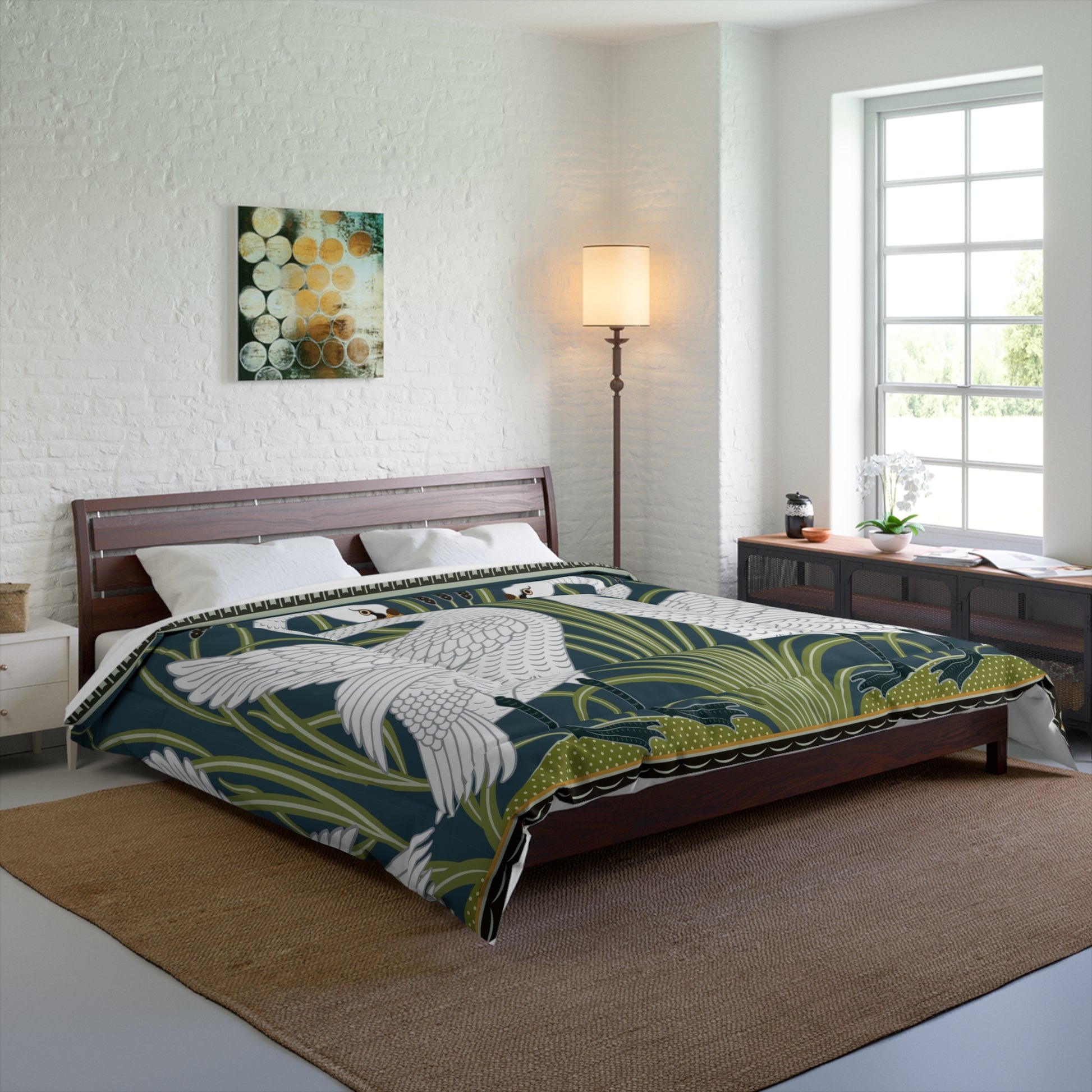 A comforter featuring a double square quilting pattern with a one-sided print of two white swans on a dark green background, surrounded by a floral border in a similar colour palette.