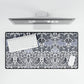 Desk setup with a decorative desk mat featuring a floral and bird pattern, keyboard, and computer monitor.