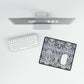 Computer monitor, keyboard, and mouse on a desk with a decorative mouse pad.