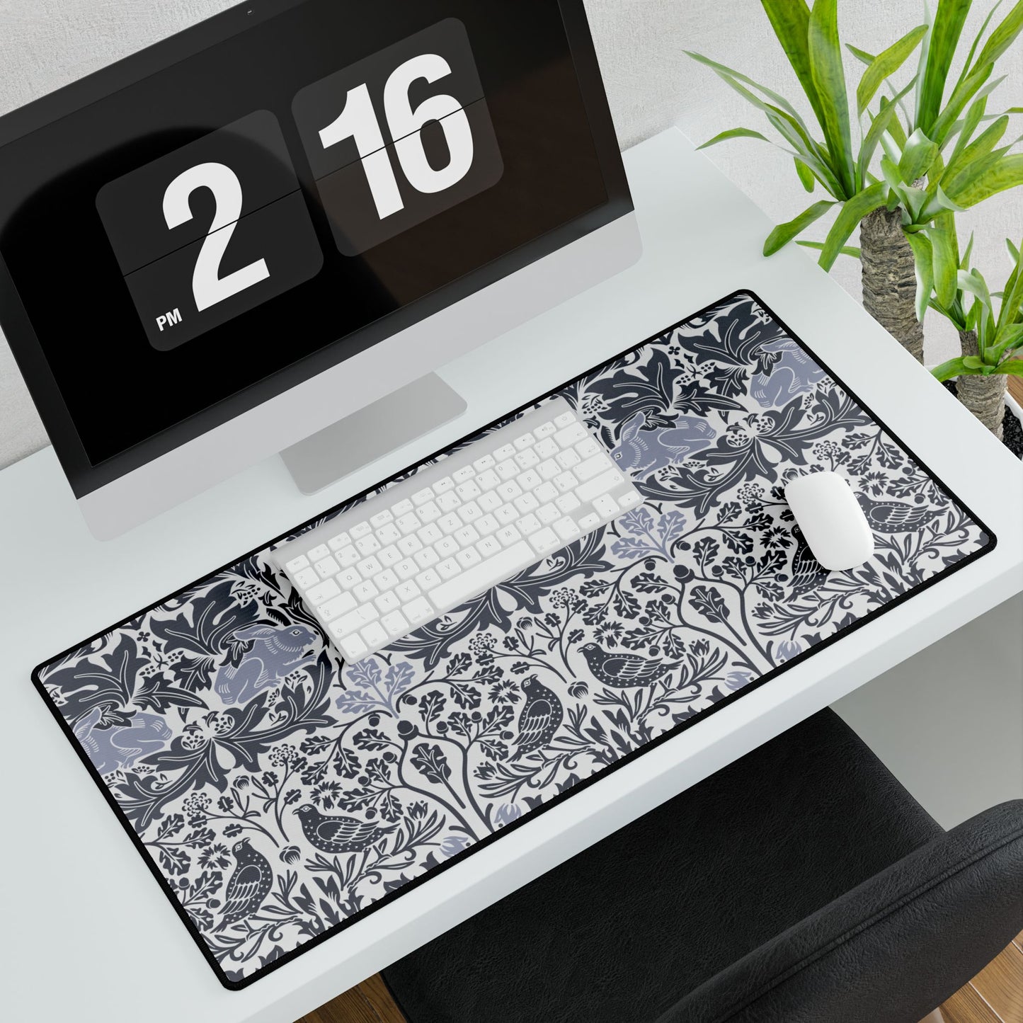 Desk setup with a large decorative mouse pad, keyboard, and computer monitor.