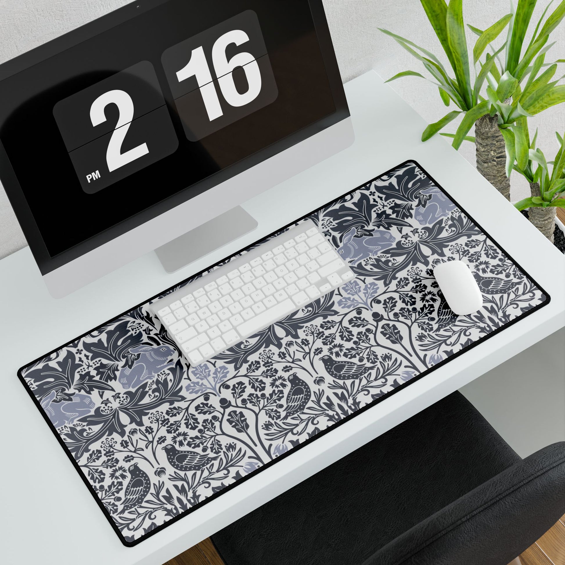 Desk setup with a large decorative mouse pad, keyboard, and computer monitor.