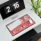 Desk setup with a red and white patterned mouse pad, keyboard, and digital clock.