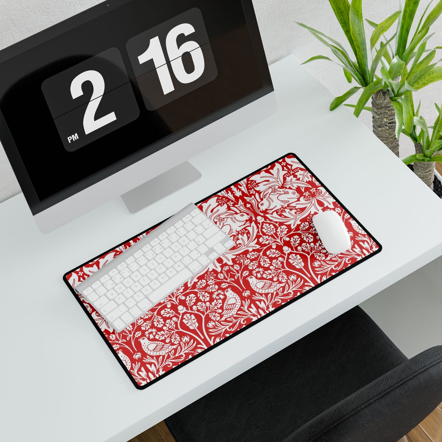 Desk setup with a red and white patterned mouse pad, keyboard, and digital clock.