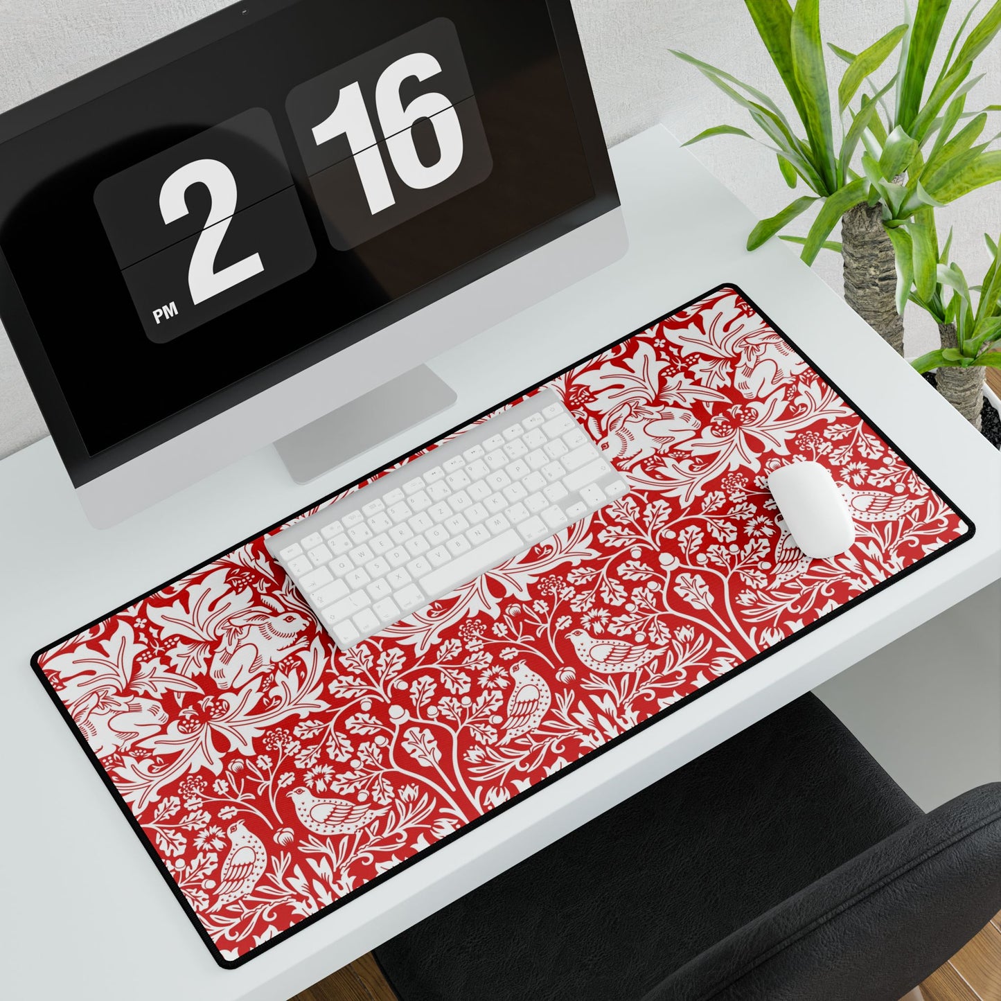 Floral patterned desk mat on a desk with a computer and clock.