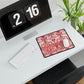 White desk with a computer setup including a monitor, keyboard, and mouse on a red and white patterned mouse pad.