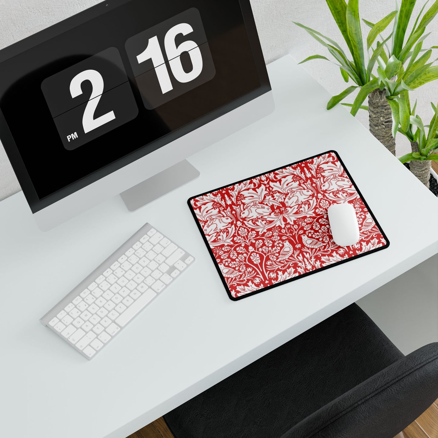White desk with a computer setup including a monitor, keyboard, and mouse on a red and white patterned mouse pad.