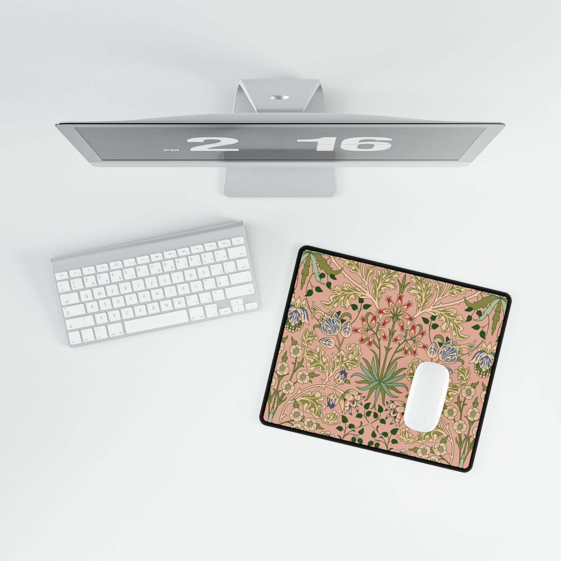 Floral mouse pad on a desk with a computer monitor and keyboard in the background