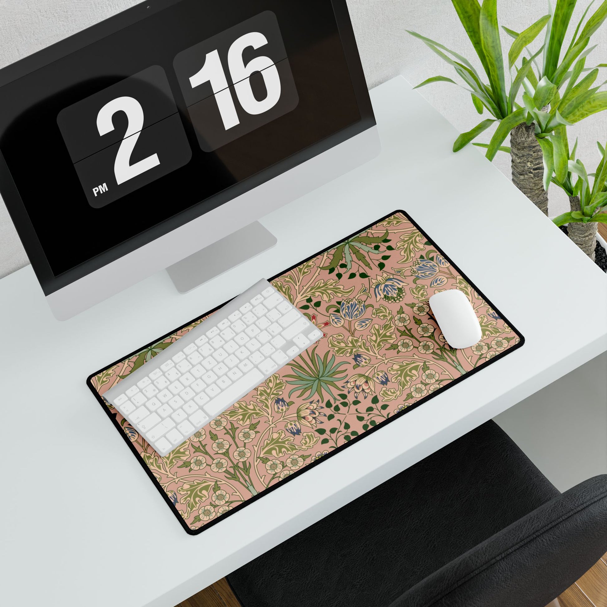 Desk setup with a floral mouse pad, keyboard, and computer monitor.