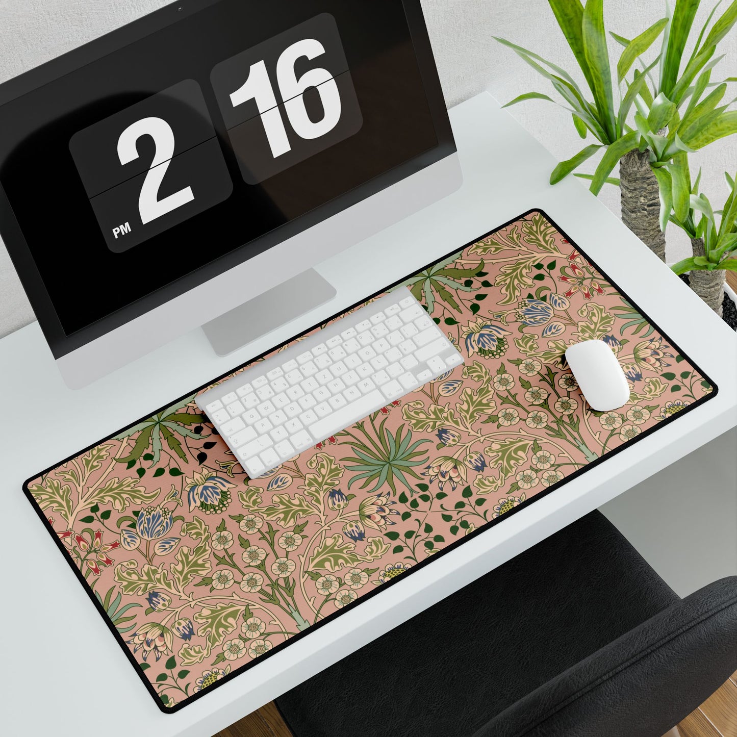 Desk setup with a floral desk mat, computer monitor, keyboard, and mouse.