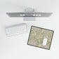 Computer monitor, keyboard, and mouse on a desk with a decorative mouse pad.