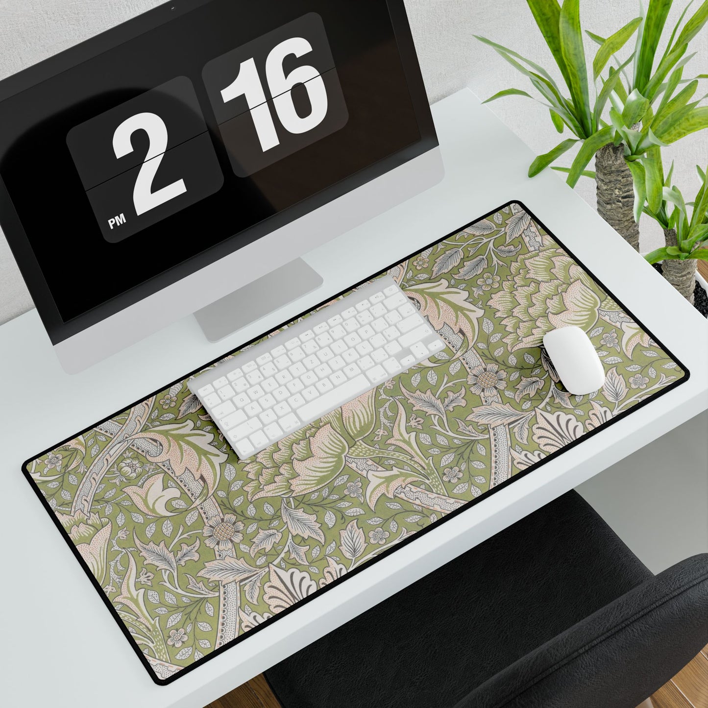 Desk setup with a patterned desk mat, keyboard, mouse, and digital clock.
