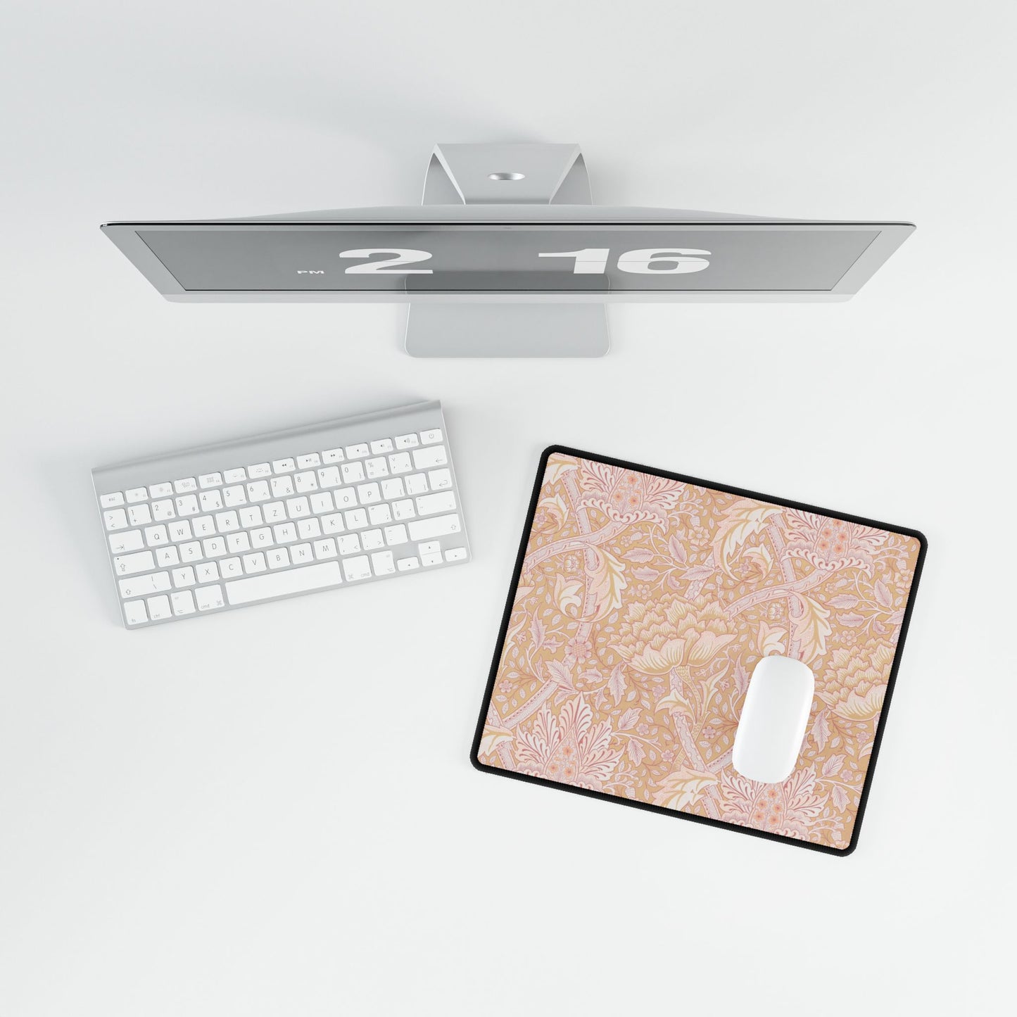 Computer monitor, keyboard, and mouse on a desk with a decorative mouse pad.