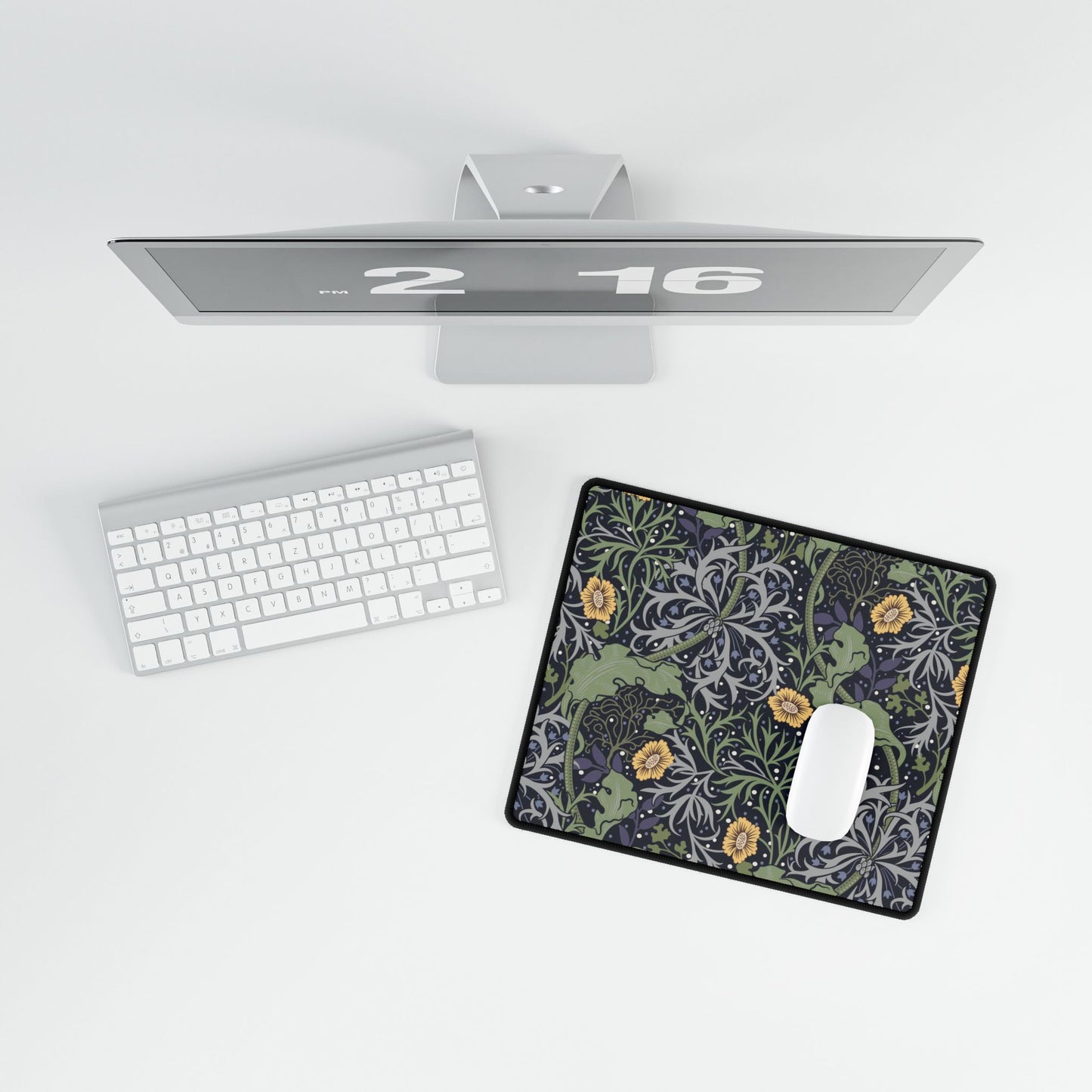 Computer monitor, keyboard, and mouse pad on a white surface