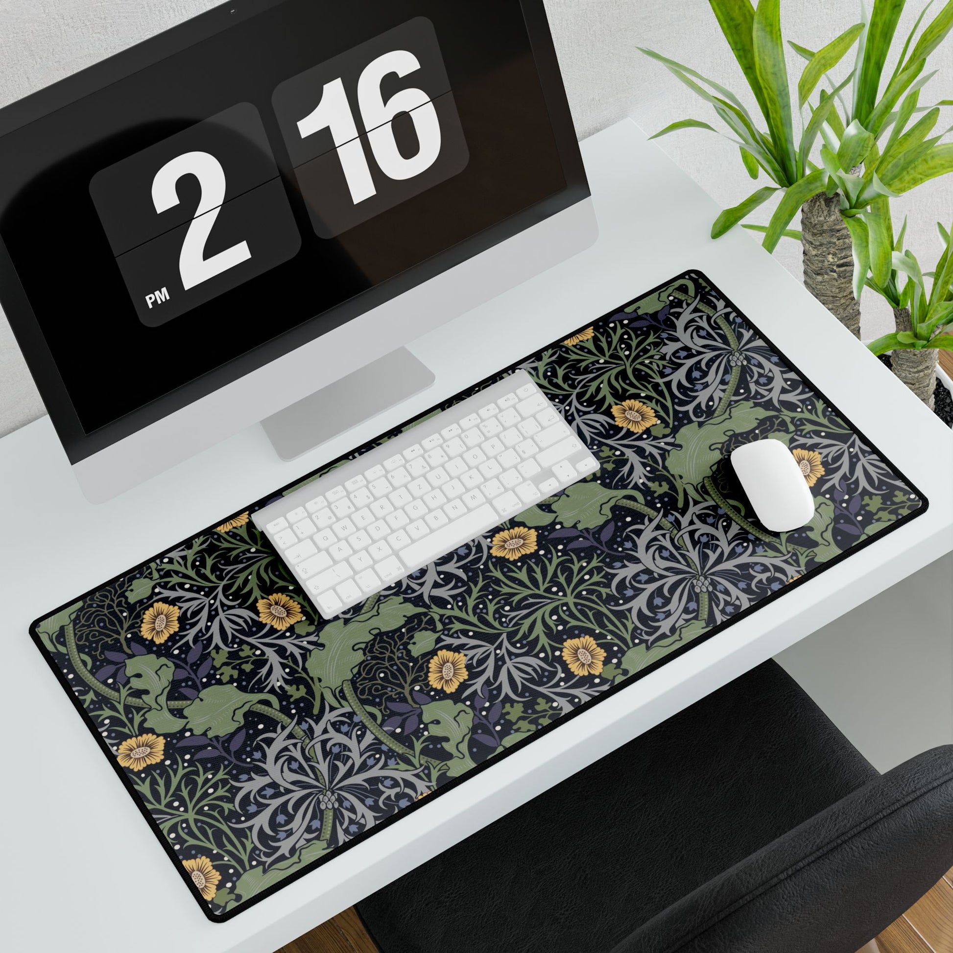 Desk setup with a computer monitor, keyboard, mouse, and large black desk mat with text.