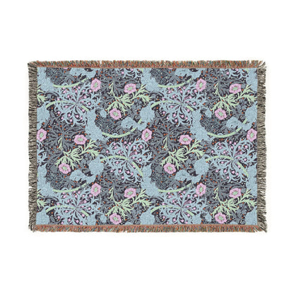 Floral patterned throw blanket with pink flowers and green leaves on a blue background